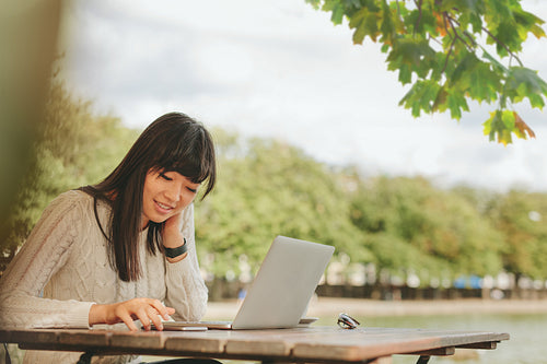 Happy woman using smartphone at coffee shop