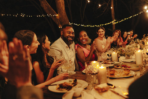 Guests joyfully celebrate at an intimate evening wedding reception outdoors