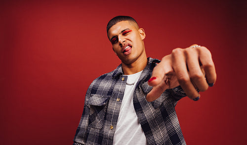 Young man winking and pointing at the camera