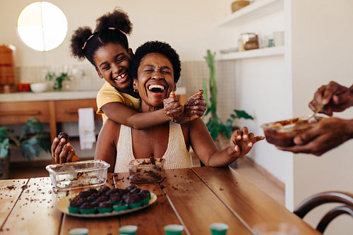 Mother and daughter having fun rolling brigadeiro, a Brazilian birthday candy
