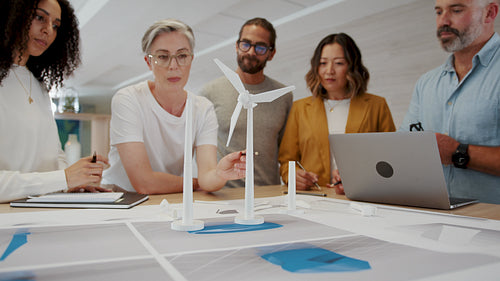 Female engineer leading her team in designing a windmill