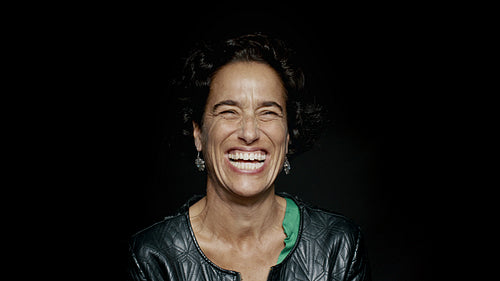 Laughing mature woman on black background
