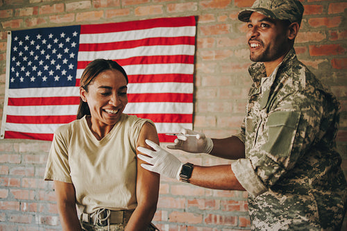 American military doctor inoculating a female soldier