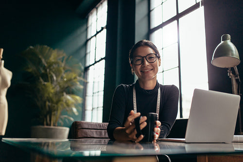 Creative female sitting in office with coffee