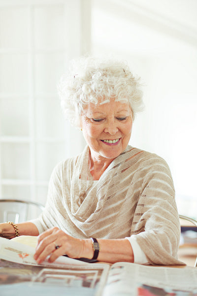 Old Lady Smiling While Reading the News