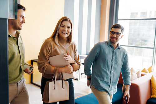 Smiling colleagues walking in an office showcasing teamwork and positivity