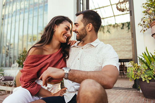 Romantic young couple laughing together outside a hotel