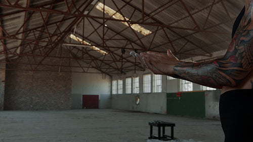 Woman applying chalk powder on hands in gym