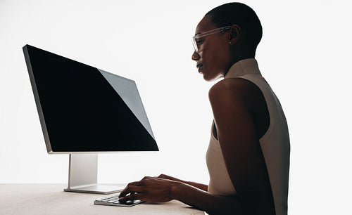 Focused professional typing on a modern computer in a minimalist environment