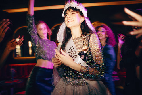 Bride-to-be celebrating at her bachelorette party with friends in a nightclub