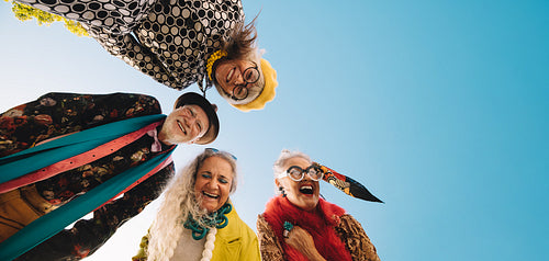 Low angle view of cheerful elderly people laughing with joy