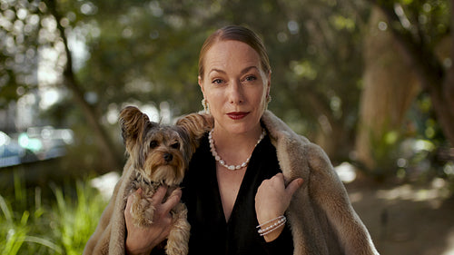 Rich woman with her pet dog outdoors
