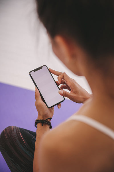 Woman using smart phone after yoga session