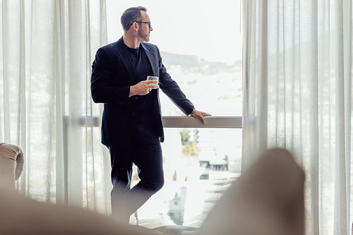 Businessman standing by a hotel room window