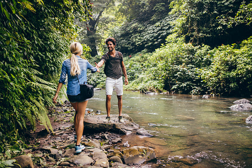 Young couple walking by the mountain stream