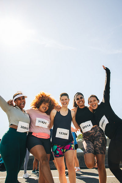 Group of female friends celebrate after finishing a 5km race
