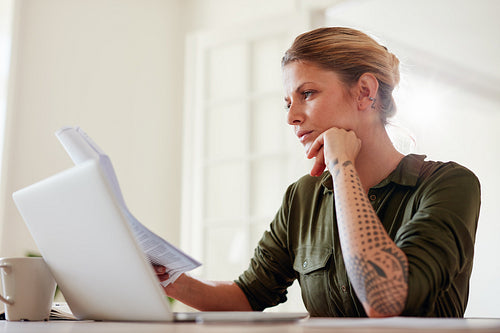 Young woman reading documents at home