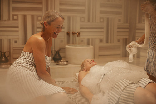 Women enjoying a relaxing treatment in a hammam spa, indulging in traditional Turkish bath rituals