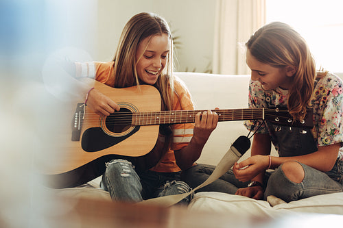 Girls having fun learning guitar