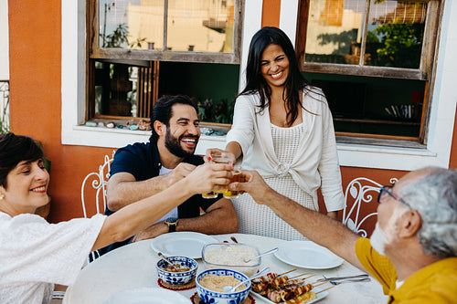 Family gathering enjoying a barbecue meal together in a cheerful atmosphere