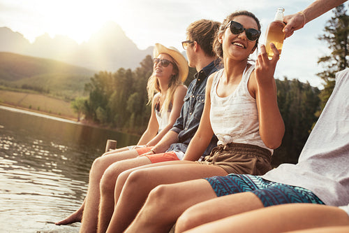 Young people sitting on a jetty on a sunny day