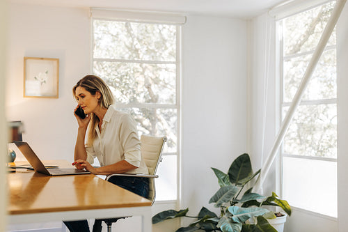 Young businesswoman making a phone call in her office