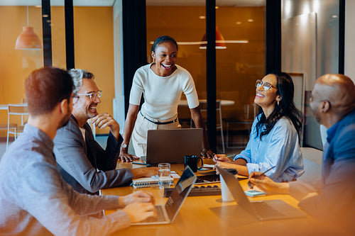 Diverse team engaged in discussion around a desk in a corporate office
