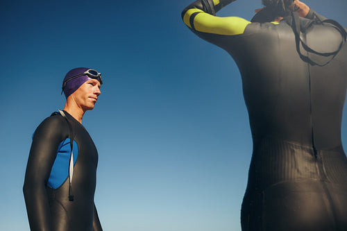 Triathlete standing with his swimming gear on