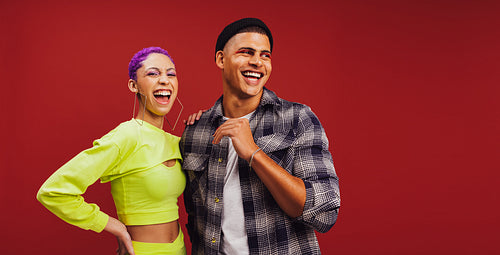 Two hipster friends smiling in a studio