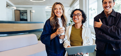 Three business professionals meet in a friendly office setting
