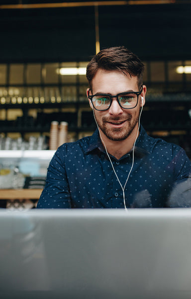 Smiling businessman working on laptop at a restaurant