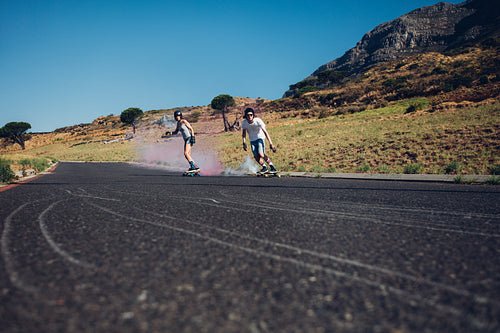 Young people skateboarding with smoke bomb