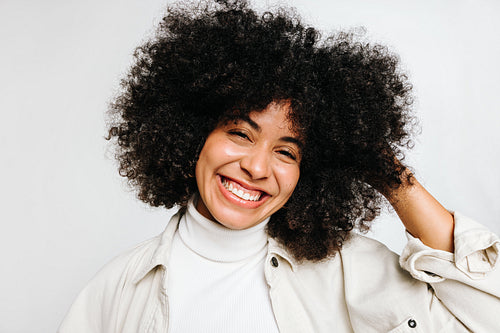 Beautiful young woman with curly hair smiling at the camera