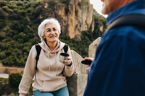 Retired couple taking a coffee break while hiking outdoors