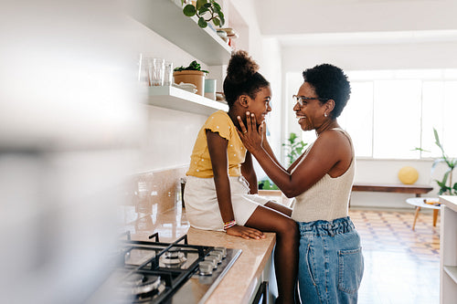 Happy mom holding her daughter's face with love