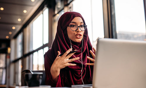Businesswoman in hijab having a video chat on laptop