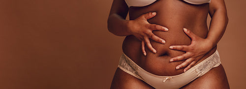 African female holding her fat belly.