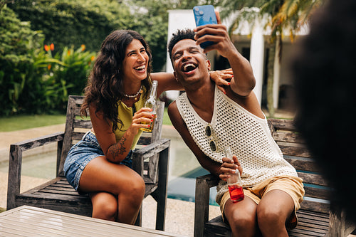 Friends take selfie at poolside party