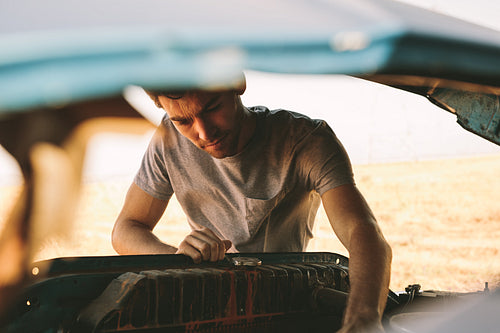 Man repairing his car on highway