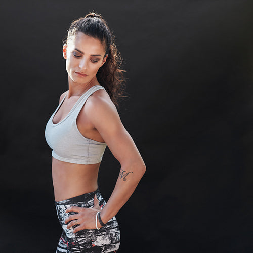 Fit young female model posing confidently in sportswear