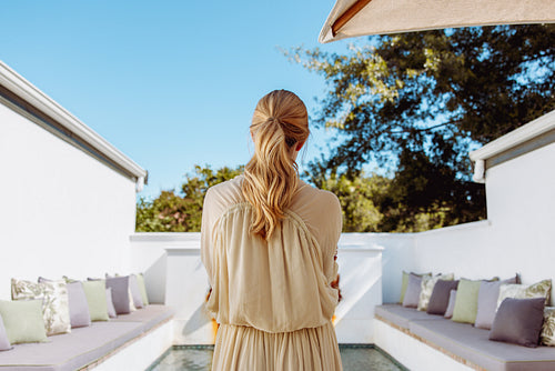 Rearview of a woman standing in front of a pool