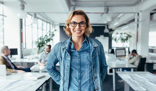 Businesswoman in office with colleagues in background