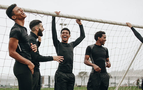 Group of footballers standing near the goalpost