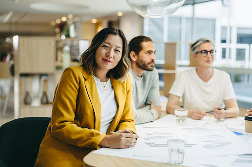 Ethnic businesswoman sitting in a meeting with her colleagues
