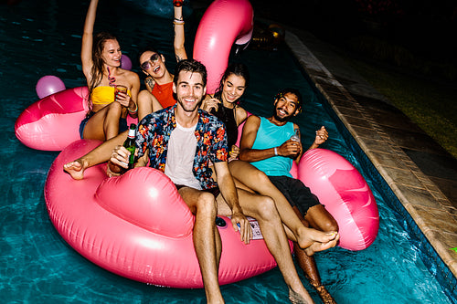 Friends hanging out at evening pool party