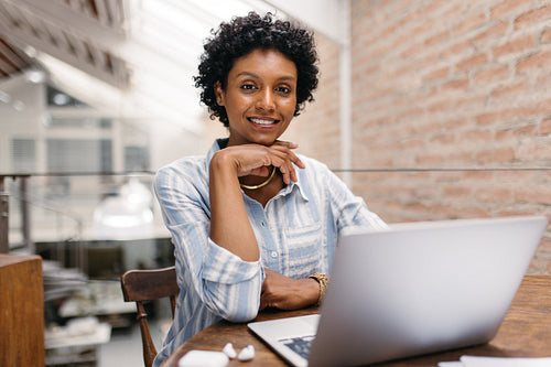 Confident small business owner smiling at the camera in a warehouse