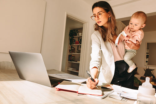 Multitasking mom working in her home office