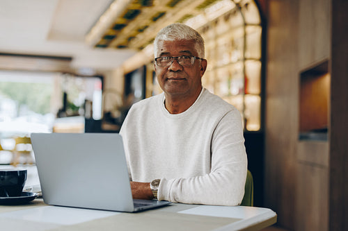 Senior businessman working in a cafe