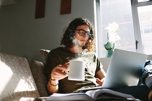 Student drinking coffee while studying at home