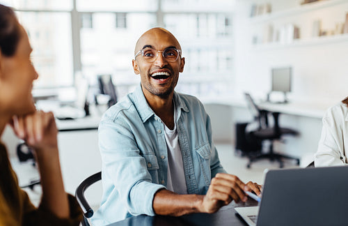 Male designer man having a discussion with his team in an office